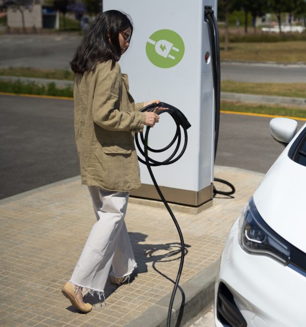 mujer-tiro-completo-cargando-auto-electrico_